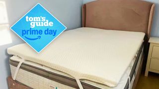 The Helix GlacioTex Premium Mattress Topper on a mattress in a light bedroom with a Prime Day deals badge in the foreground. 