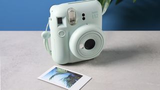 A mint green Fujifilm Instax mini 12 instant camera