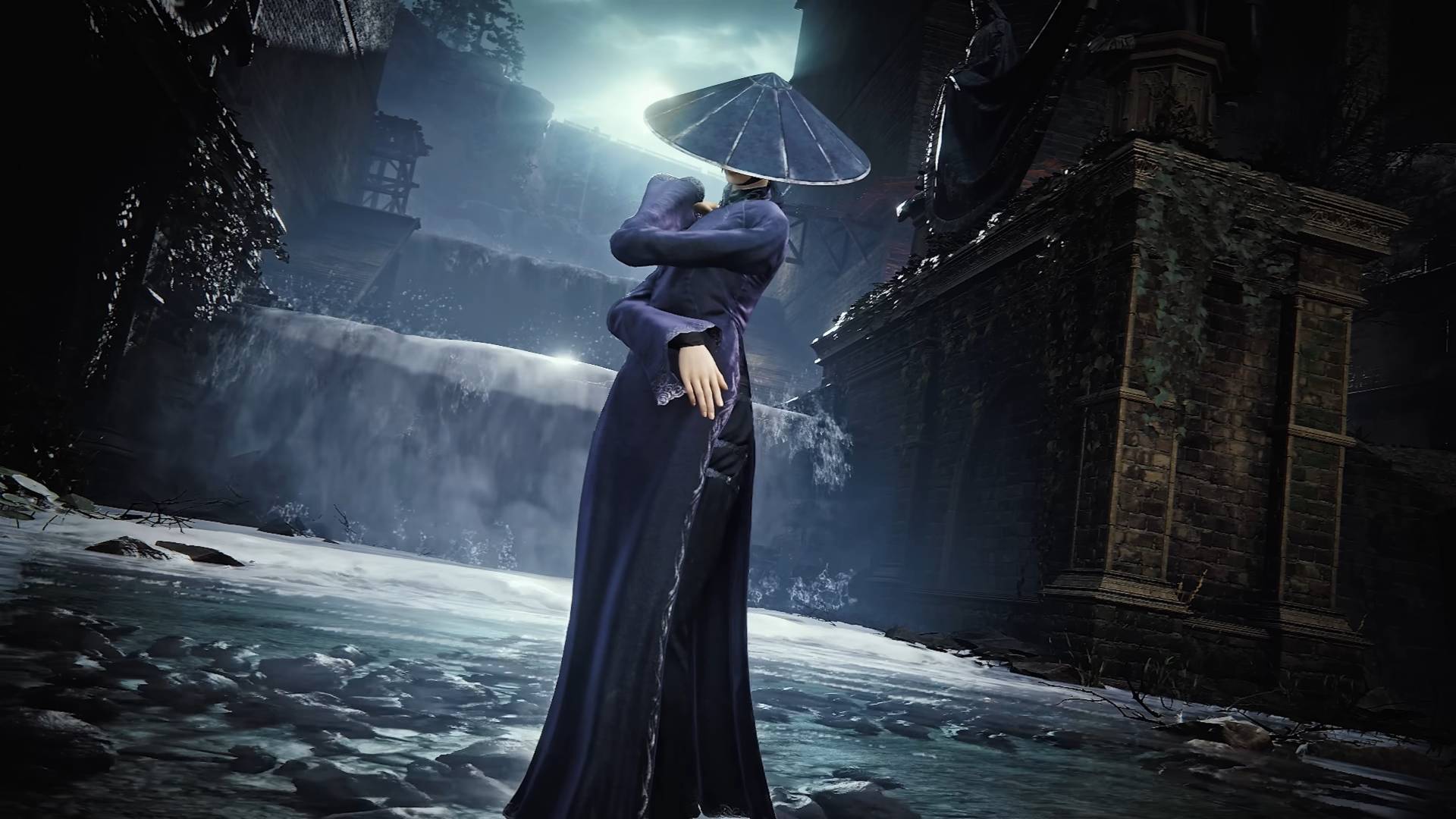 The Duskbloods Trang Lanh woman in dark blue dress and hat standing in front of a small waterfall