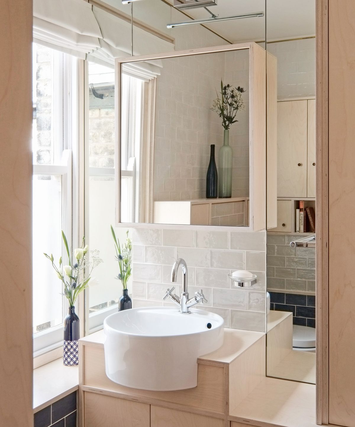 A bathroom sink set in a bespoke birch plywood storage