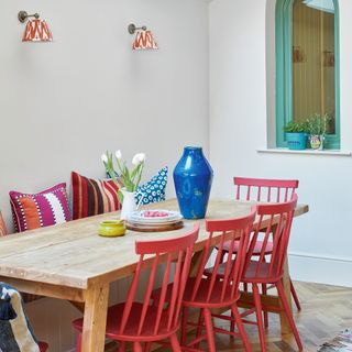 dining table and chairs in a kitchen diner with a wooden table and red painted dining chairs