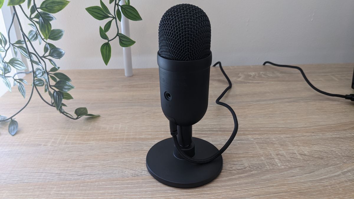 Razer Seiren V2 X USB microphone on a wooden desk, plugged into a Razer Blade 14 laptop.