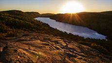 Sunrise above Michigan's Lake of the Clouds. We see a ridge of basalt in the foreground.