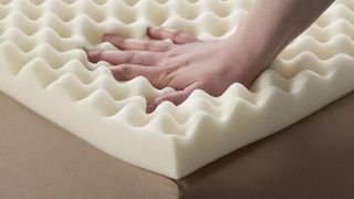 A hand checks the temperature of the Future Foam Enhance Highloft 2 Memory Foam Topper