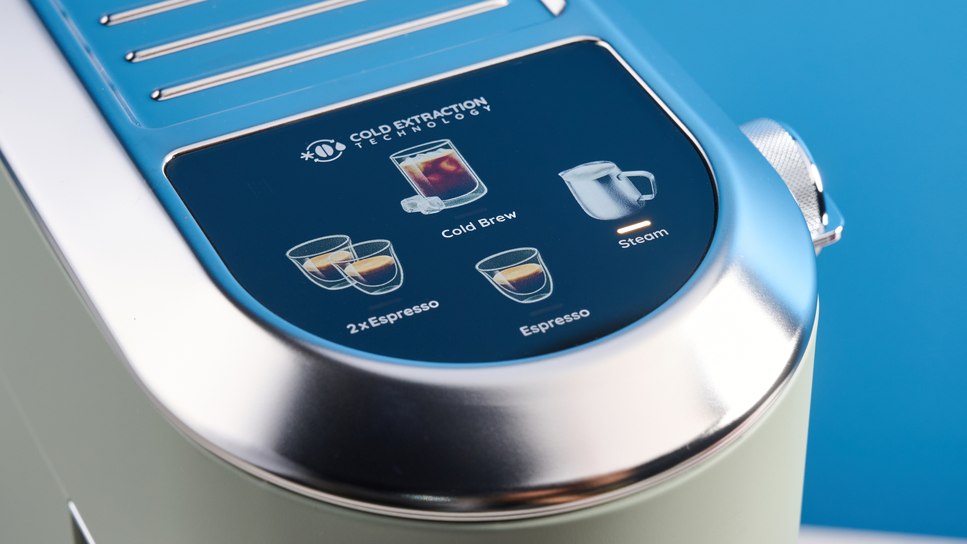 DeLonghi Dedica Duo in the green colorway with accessories photographed on a blue background.