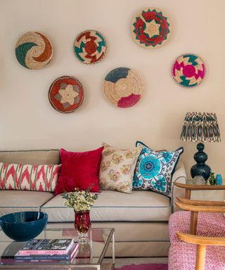 Neutral sitting room with colorful baskets displayed as a group on the wall