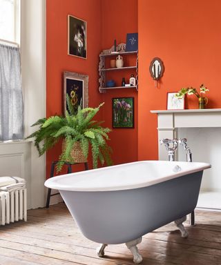 Orange walls, white fireplace, clawfoot bath