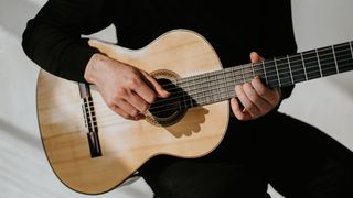 Man in black clothes plays Flamenco guitar