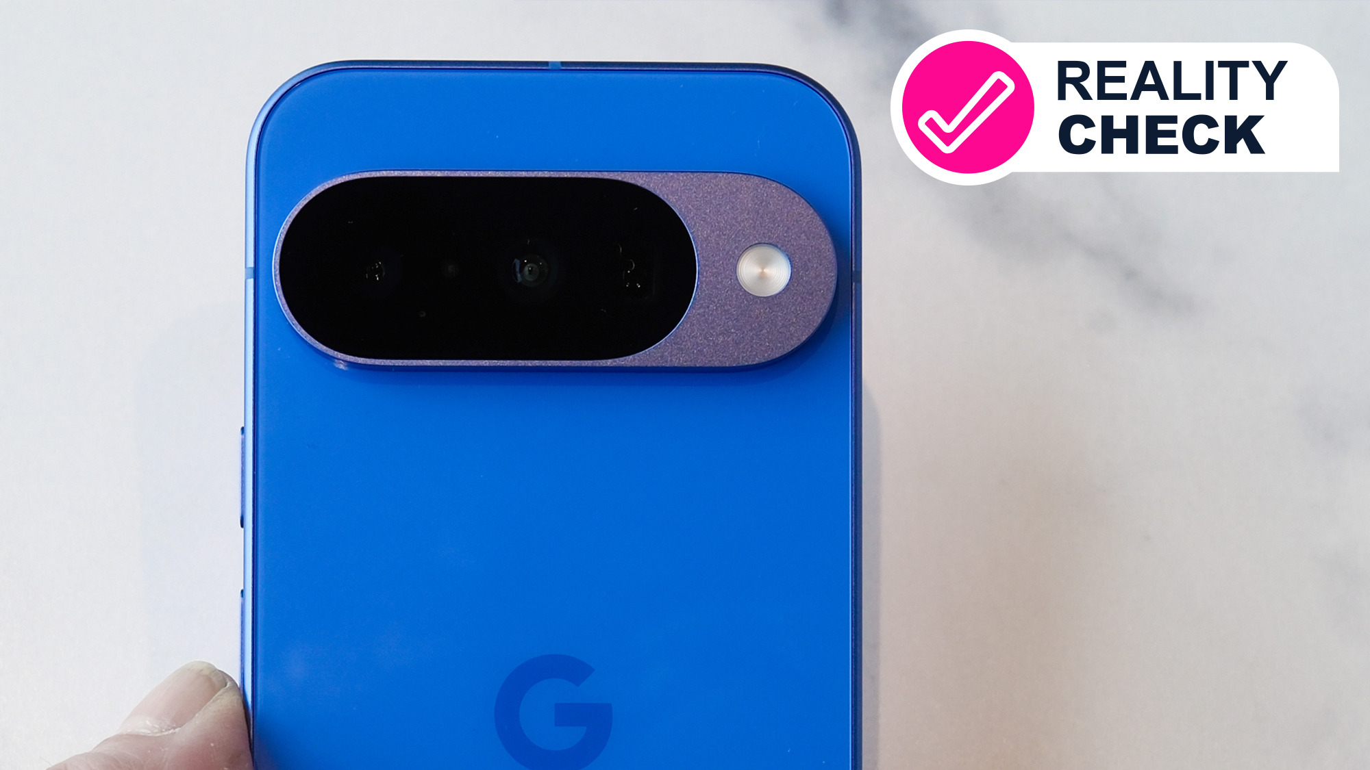 An indigo Google Pixel 10 phone on a marble surface