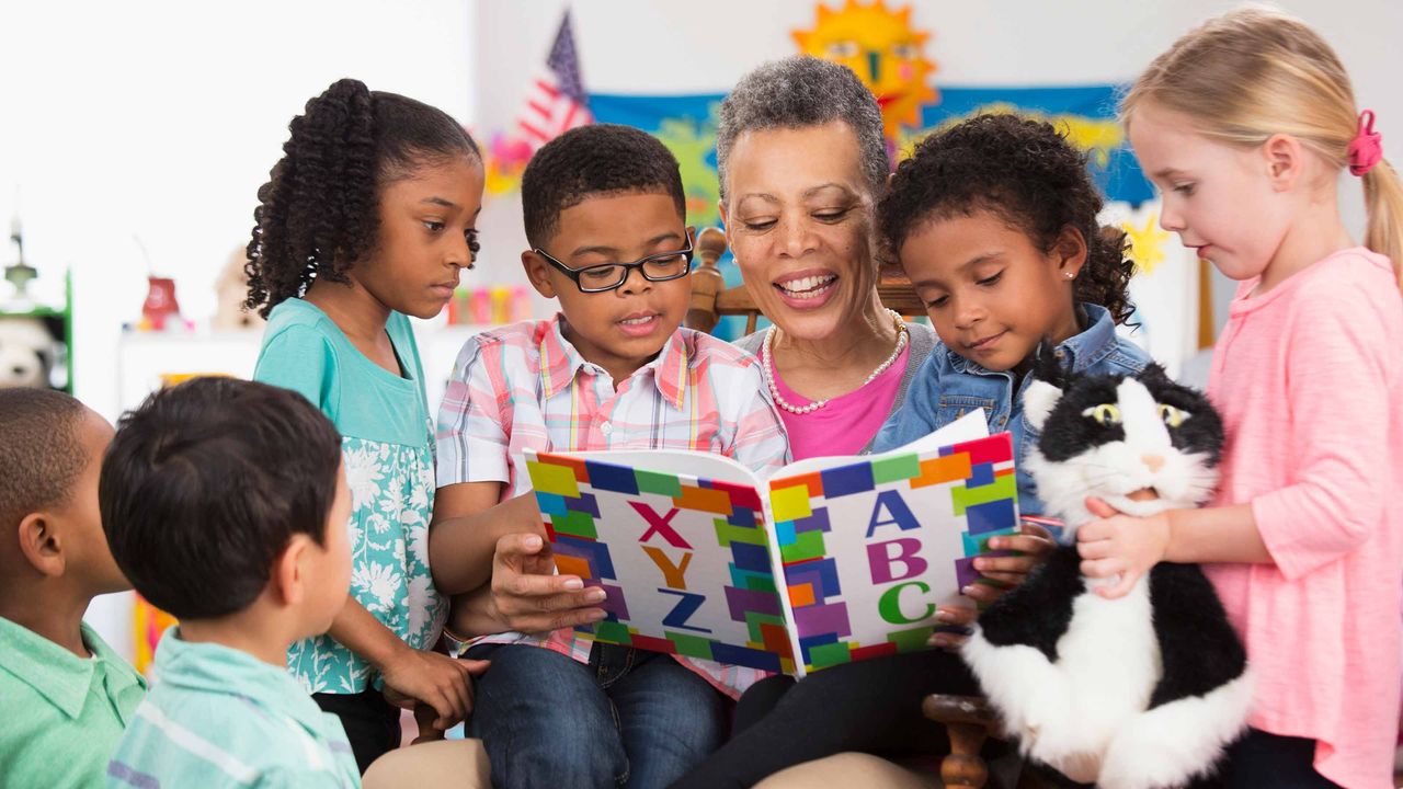 picture of childcare teacher reading to children