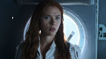 Black Widow in her white suit talking to Alexi in the back of a helicopter