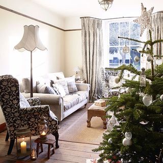 living room with wooden flooring and grey sofa and black printed armchair