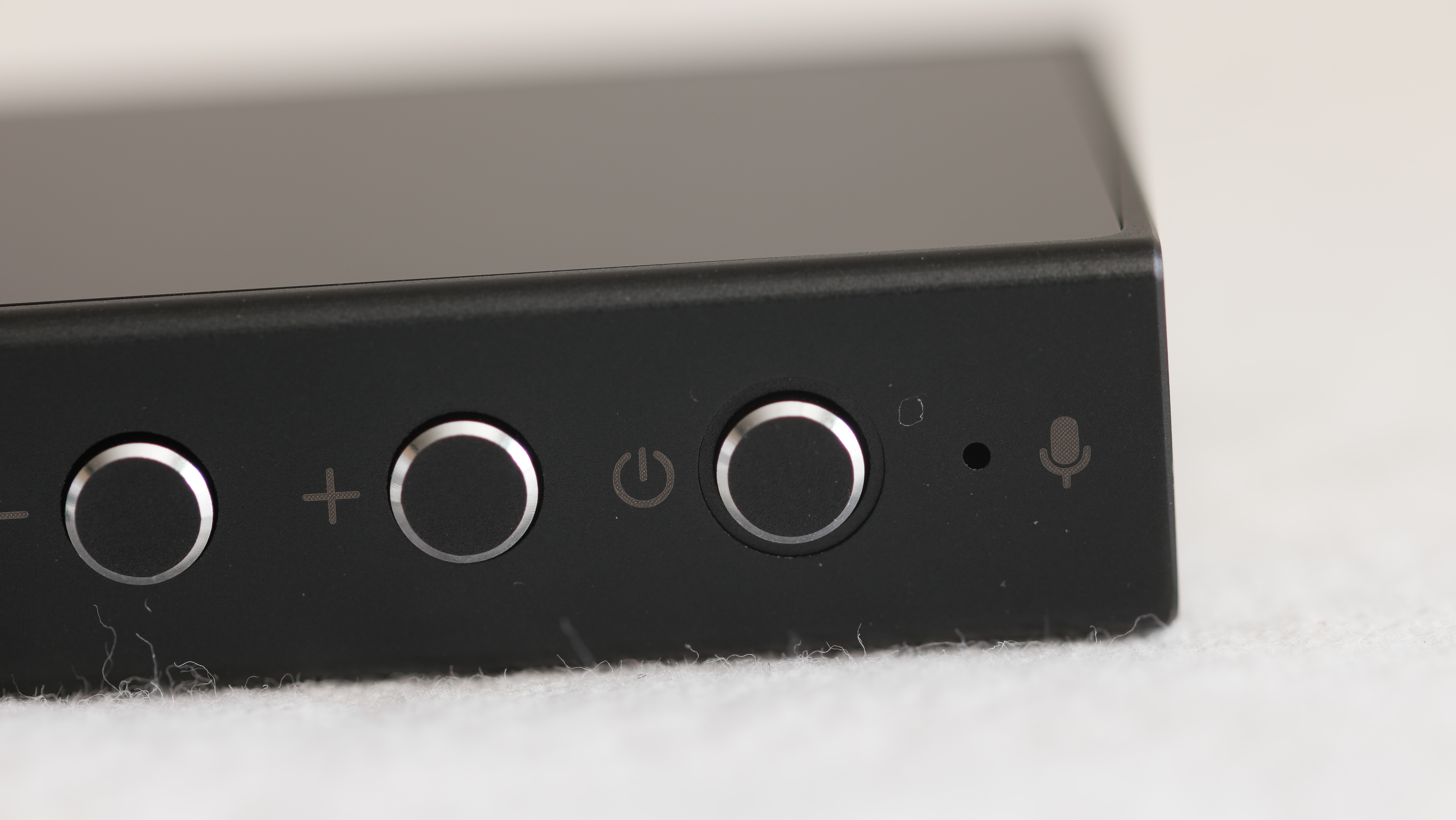 Questyle M18i showing power and volume buttons, along with the microphone port