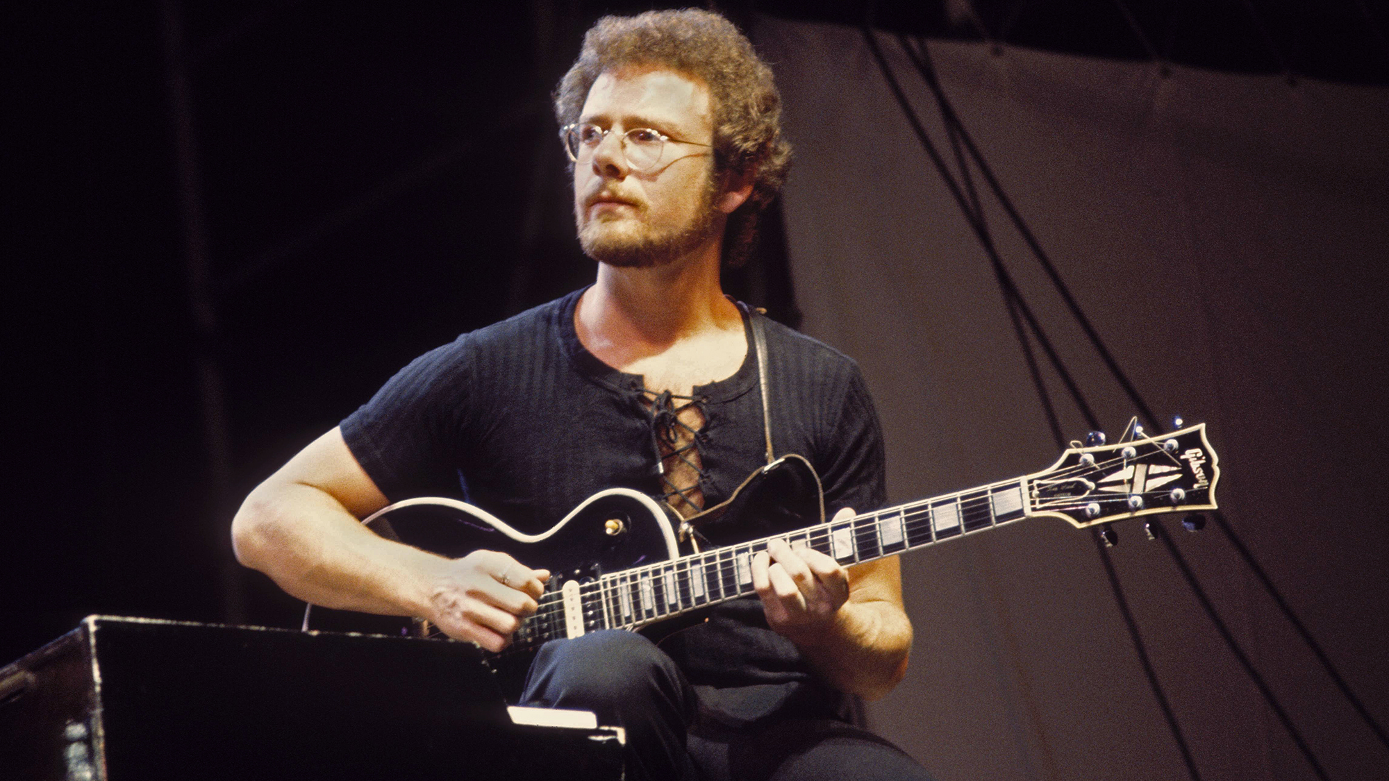 Robert Fripp performing live on stage, playing Gibson Les Paul guitar, 