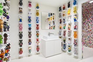 Room with basin and shelves on walls with toys on the shelves