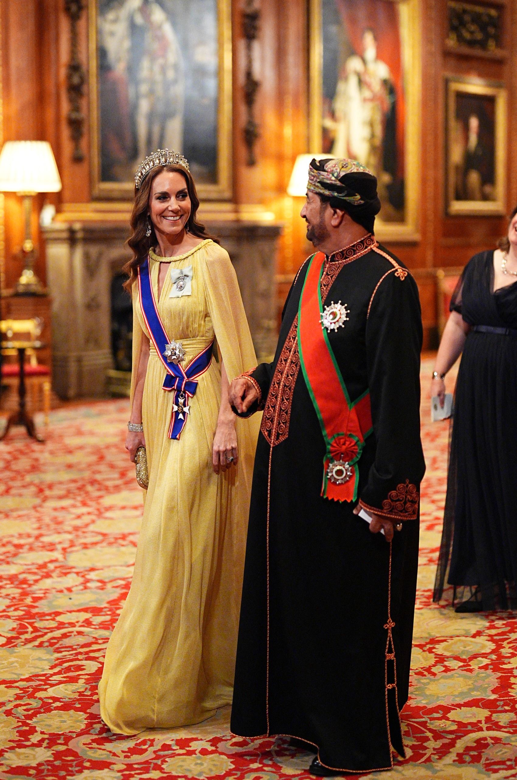Khalid bin Hilal Al Busaidi walking with Princess Kate in a yellow gown at a state banquet