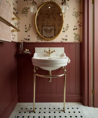 a bold powder room with a mosaic tiled floor and burgundy wall paneling