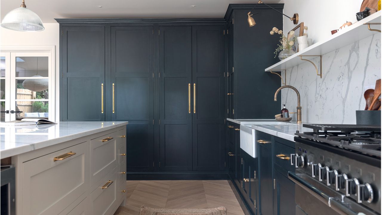 kitchen with black cabinets, black oven and white marble splashback with and white shelving with a white island