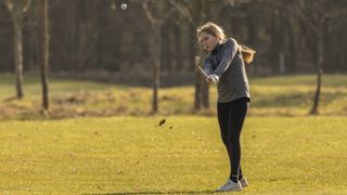 Junior girl golfer playing off fairway