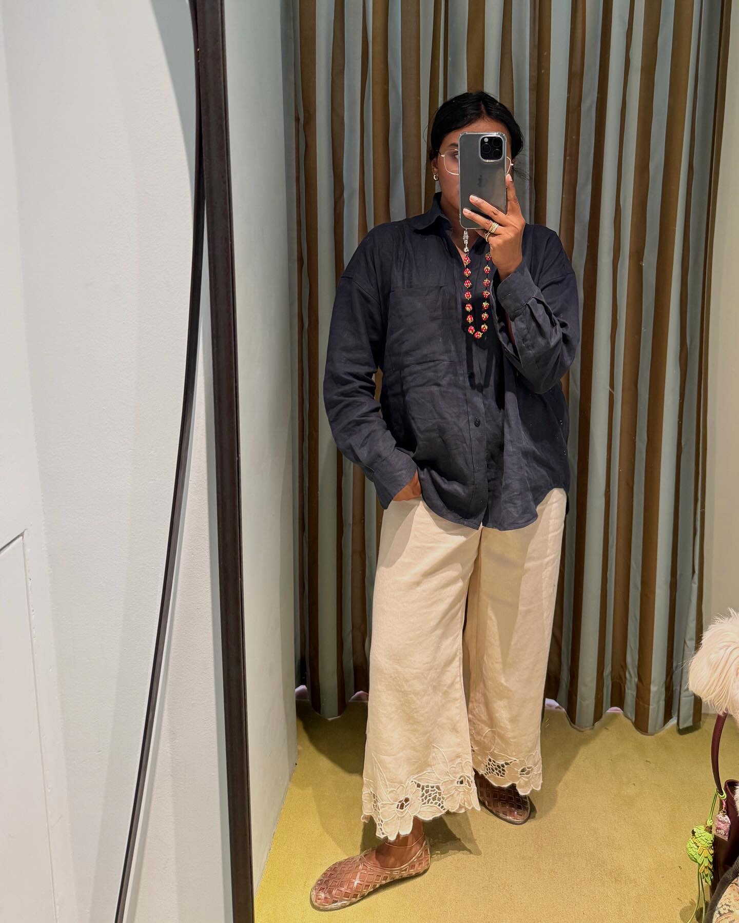 An image of @chiarasatelier wearing broderie anglaise trousers with jelly sandals.