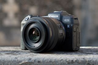 The Canon EOS RP, one of the best Canon cameras, sitting on a stone wall