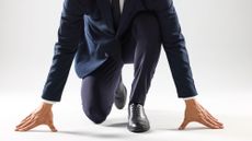 Businessman in starting position for run on white background, closeup