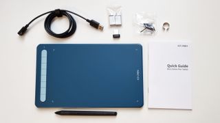A photo of the XP-Pen Deco MW art tablet and included accessories
