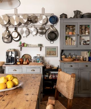 Rustic gray kitchen with pans hanging on the wall