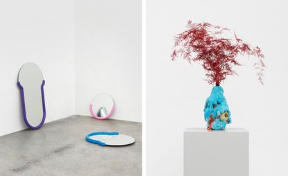Left, Three Mirrors - one with a semi-circle head and deep U shaped base with purple outline; one small circle mirror with pink semi-circle outline; one on the floor with a blue outline.. Right, A blue vase with an orange flower