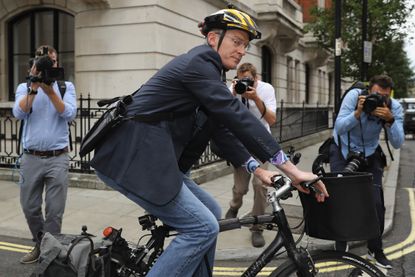 Jeremy Vine riding a bike in 2017 surrounded by paparazzi