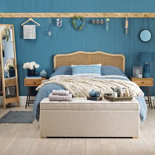 blue painted panelled bedroom with peg rail