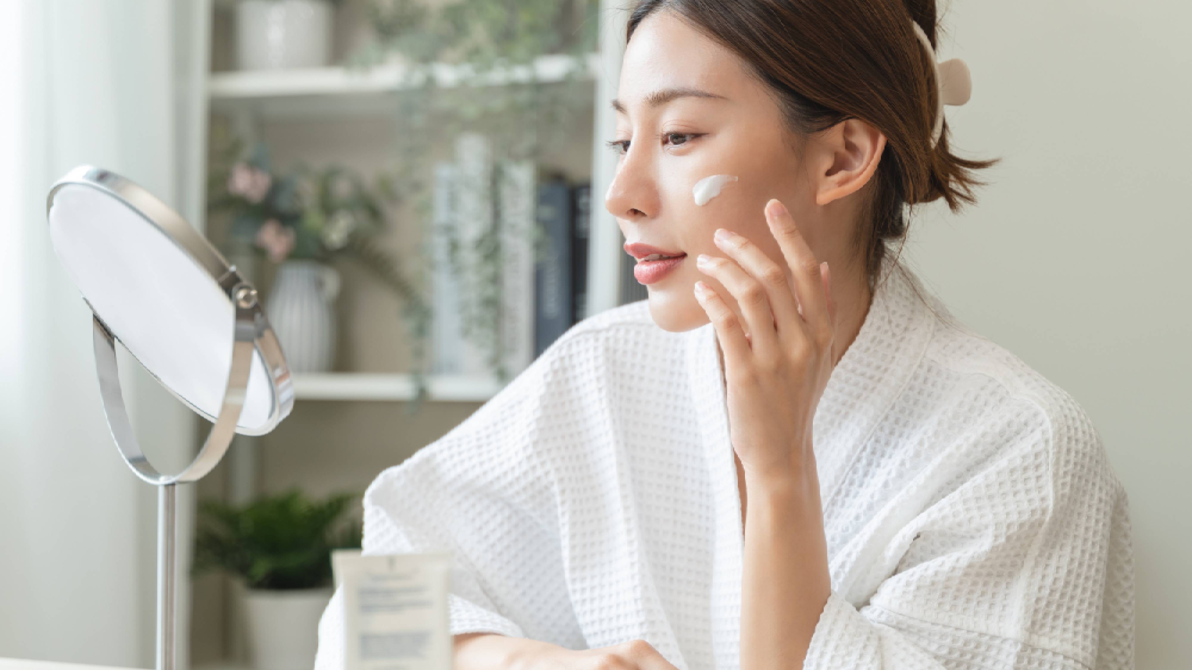 Woman applying sunscreen to face