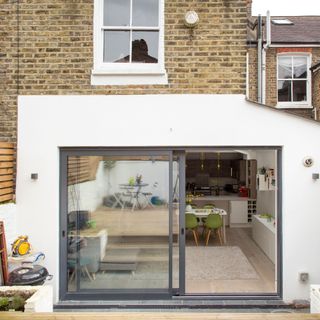 Sliding patio doors with grey aluminium frames offering views of small garden