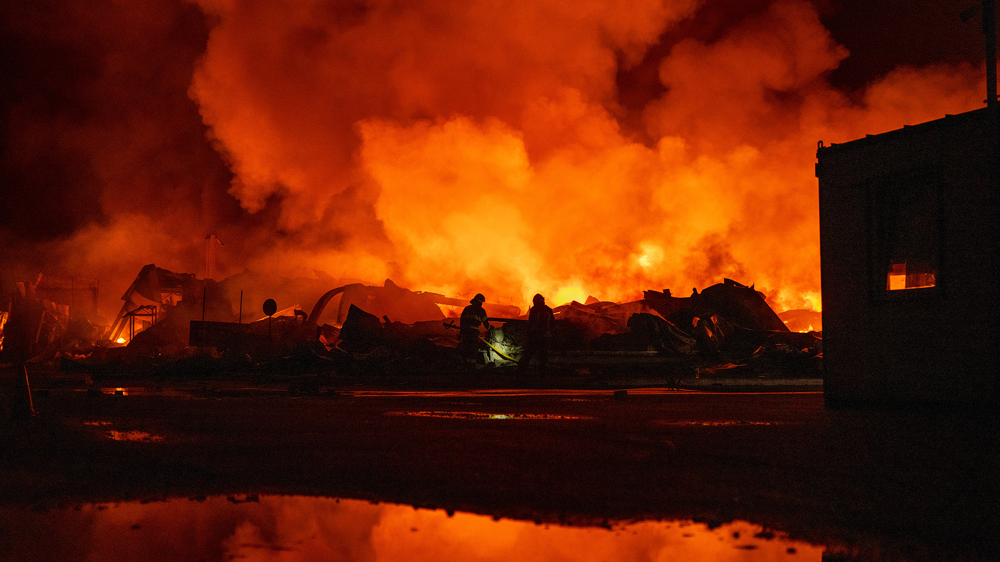 Firefighters put out a fire after Russian missiles hit a warehouse in Kyiv, Ukraine