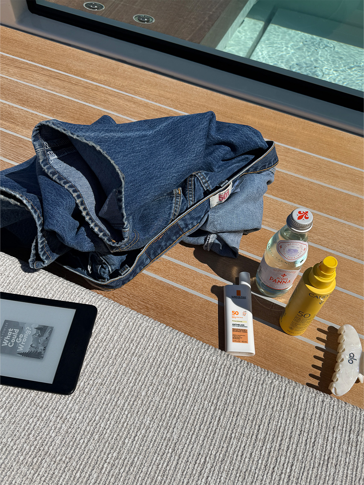 Pool day essentials, like sunscreen and hair clips.