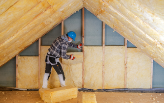 Man insulating inside a roof