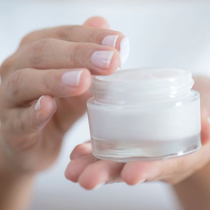 Rich creams - image of a woman dipping her fingers into a pot of cream