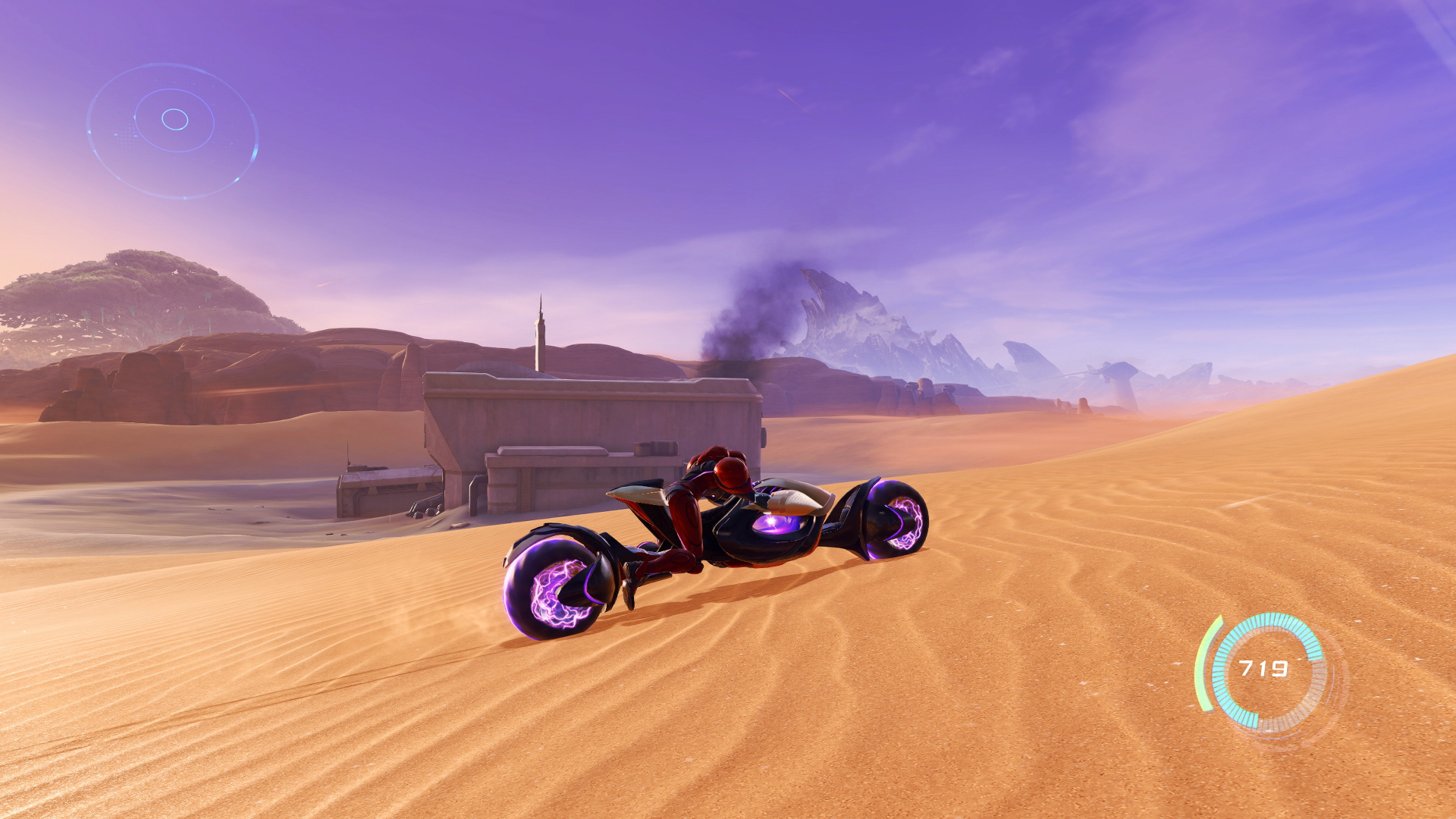 Samus drives through the desert on her motorcycle in Metroid Prime 4 Beyond, with an abandoned facility in the background.
