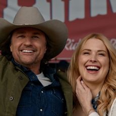 jack and mel smile and throw their hands in the air at a rodeo in virgin river season 7