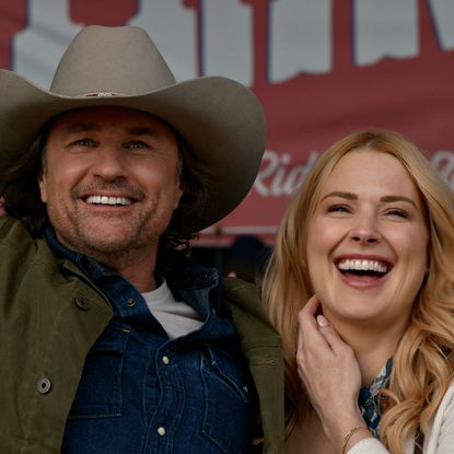 jack and mel smile and throw their hands in the air at a rodeo in virgin river season 7