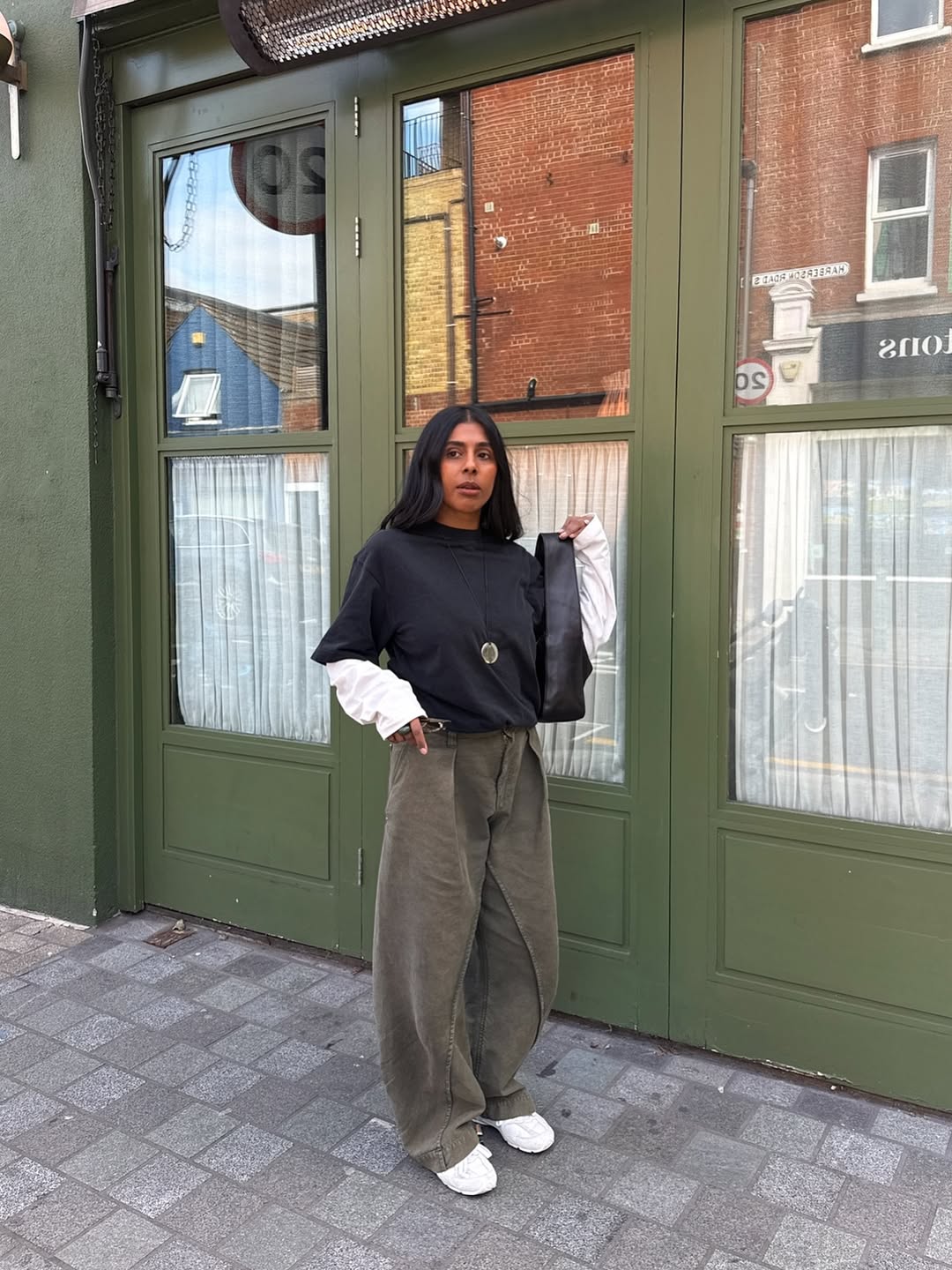 monikh wears khaki trousers navy t-shirt