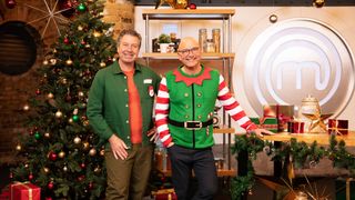 John Torode and Gregg Wallace standing in the MasterChef kitchen (which has had a Christmas makeover) for Celebrity MasterChef: Christmas Cook-Off 2023.