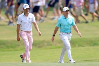 Justin Thomas and Rory McIlroy walk up the fairway together