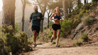 a man and woman trail running