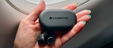 Cambridge Audio Melomania M100 held in a hand, near the window of an aircraft