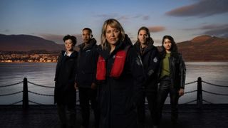 Annika season 2: A composite shot of the cast of Annika's second season, standing in front of a waterfront view. From left to right: Katie Leung as DC Blair Ferguson, Ukweli Roach as DS Tyrone Clarke, Nicola Walker as DI Annika Strandhed, Jamie Sives as DS Michael McAndrews, Varada Sethu as DC Harper 