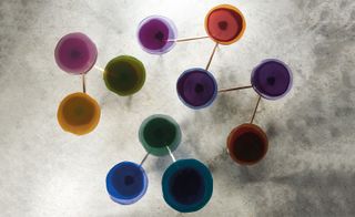 Contemporary miniature colourful side tables photographed from above on a grey surface