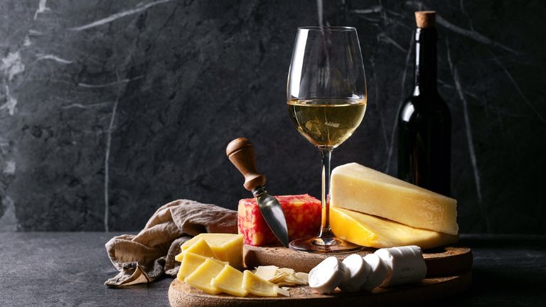 Wine and Cheese On Table Against Wall
