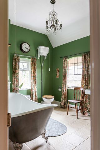 green bathroom with freestanding bath and toilet