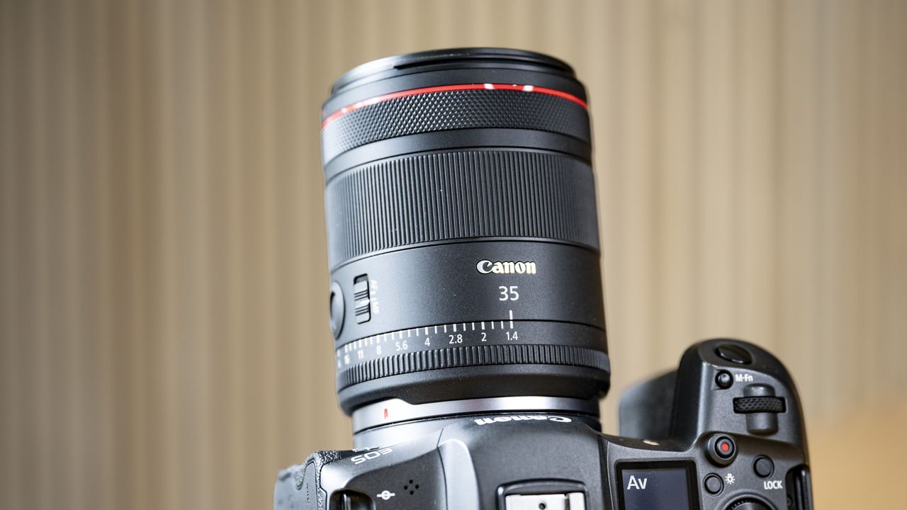 The Canon RF 35mm F1.4 lens on a wooden table, attached to a Canon EOS R5